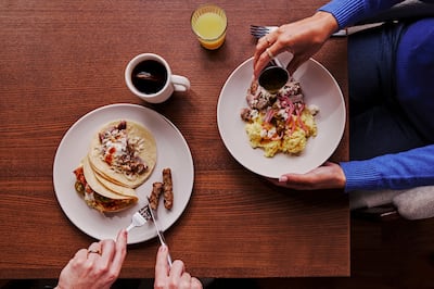 two plates on a table of breakfast tacos 