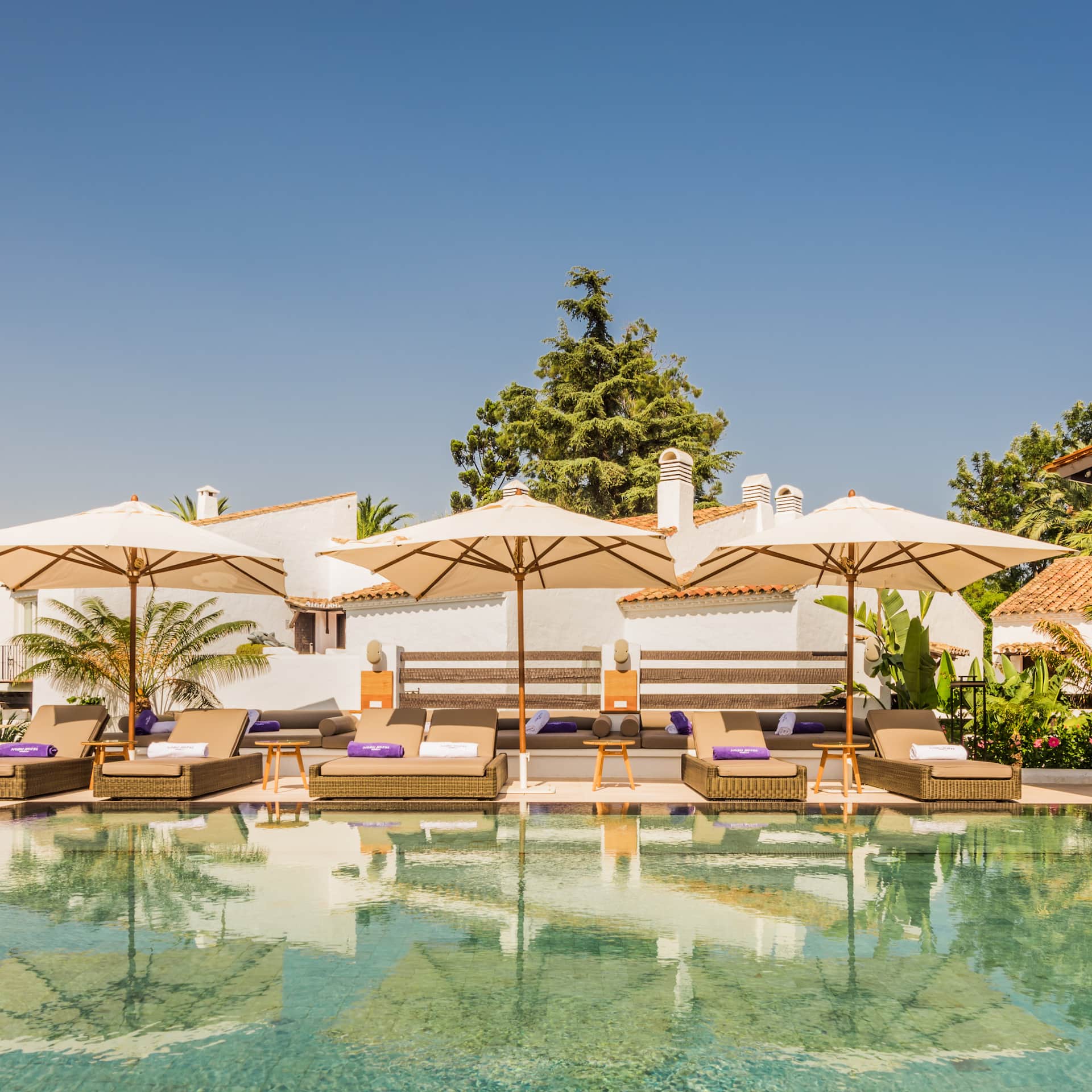 A pool with lounge chairs and umbrellas