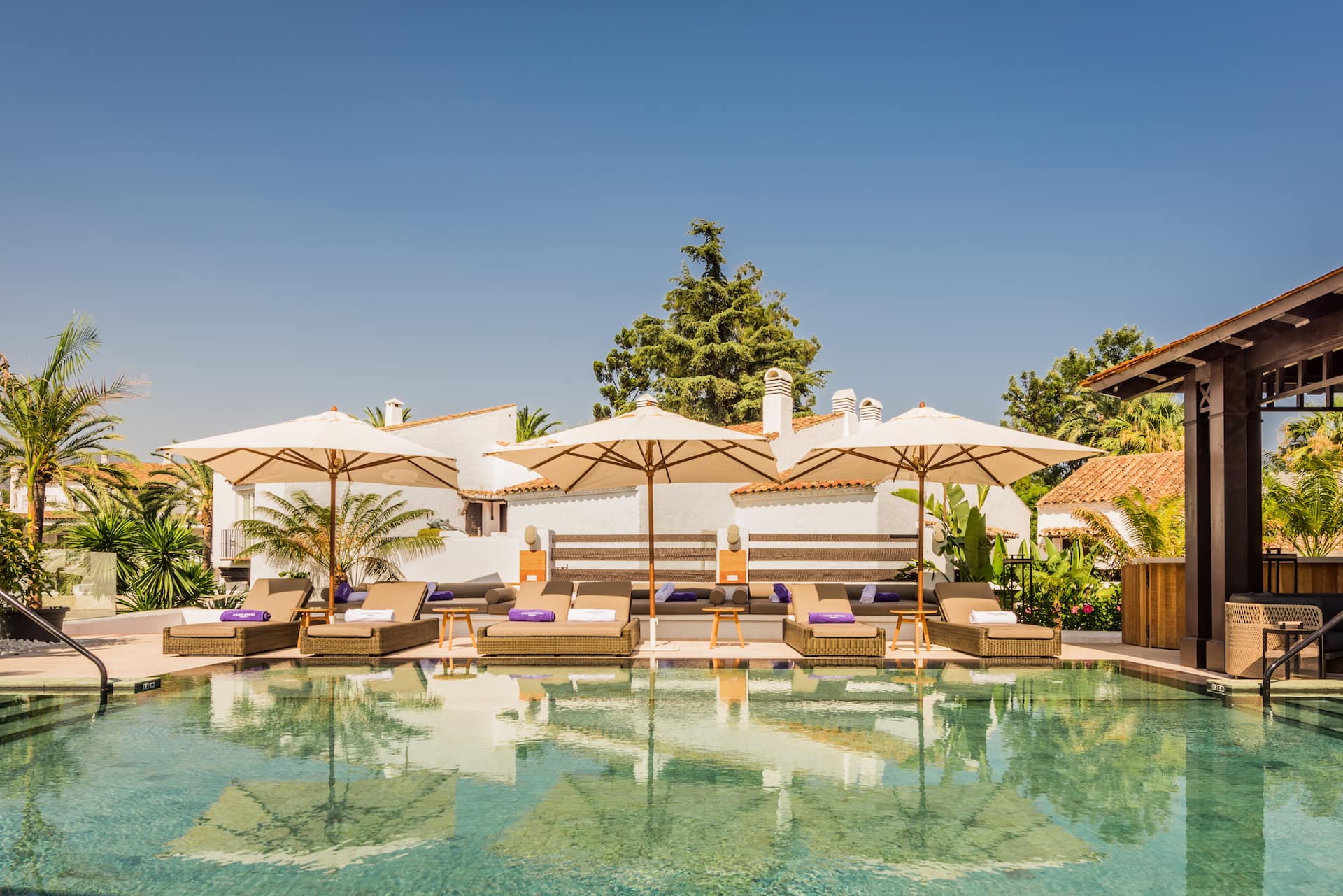 A pool with lounge chairs and umbrellas